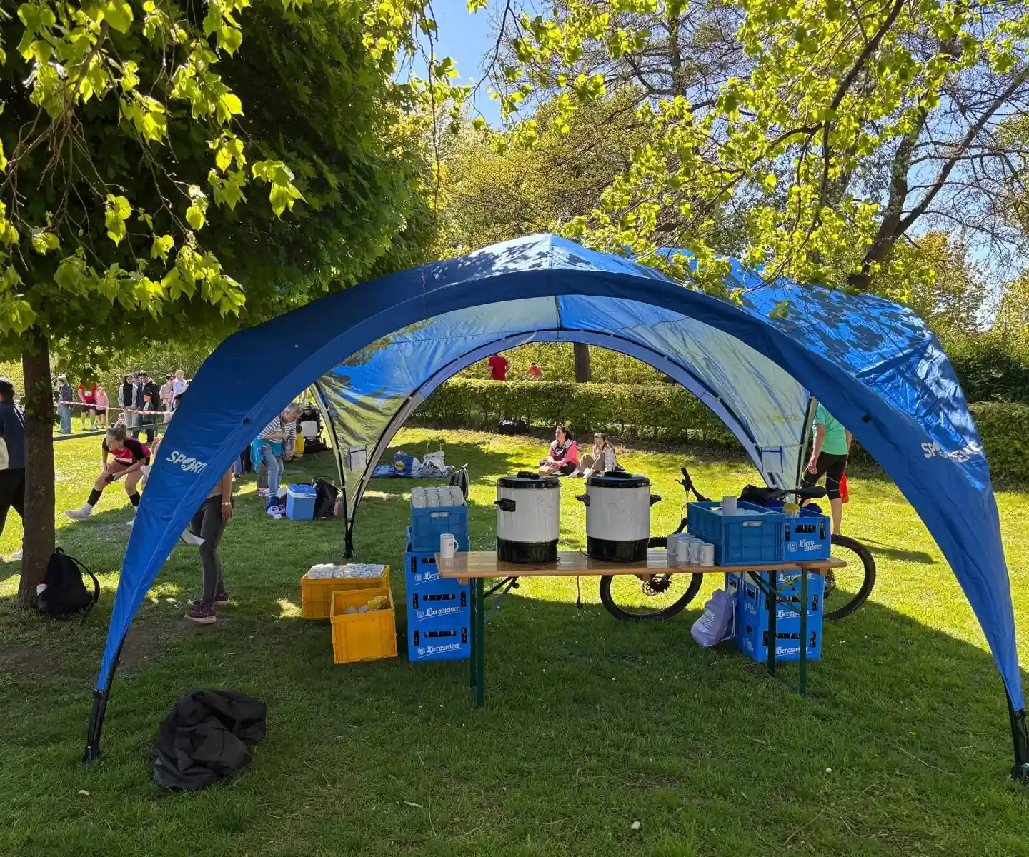 Verpflegungsstelle unter dem blauen Pavillon: Thermobehälter und Becher auf dem Tisch
