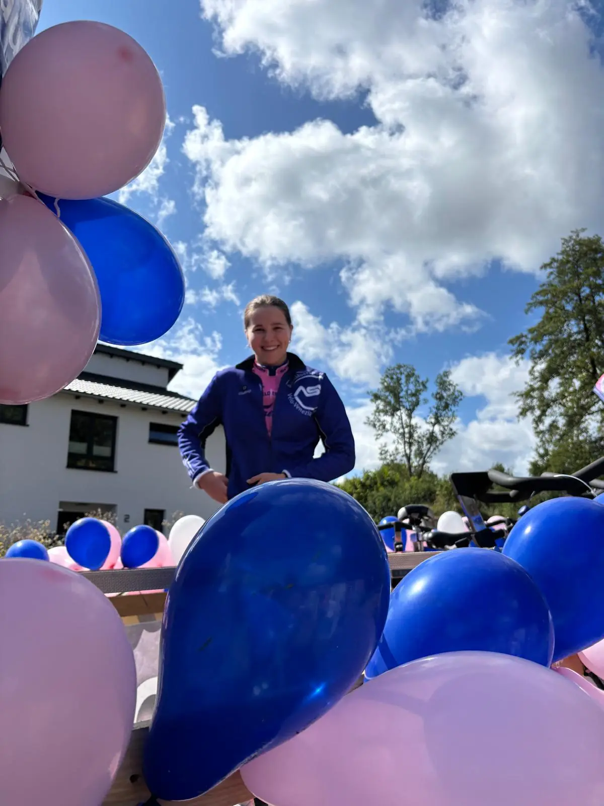 Vereinsmitglied in blauer Jacke auf dem mit Luftballons geschmückten Umzugswagen
